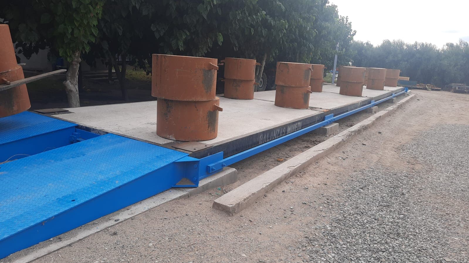 Báscula camionera con estructura metálica y pesas patrón para calibración