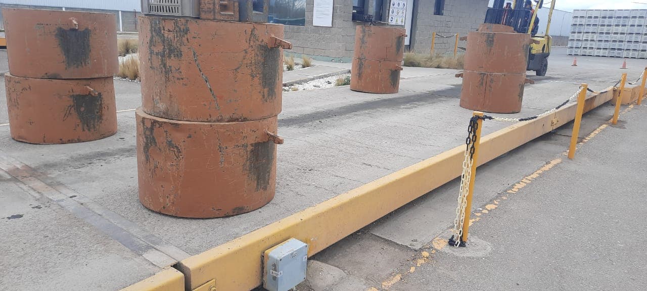 Detalle de pesas patrón apoyadas junto a la báscula